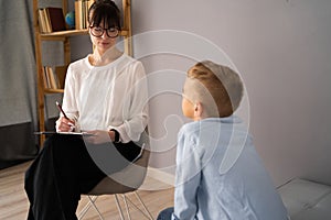 Professional child psychologist working with boy at office