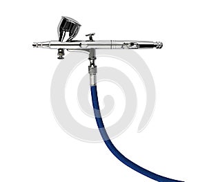 Professional chrome metal airbrush acrylic color paint gun tool with blue hose isolated white background. industry art scale model