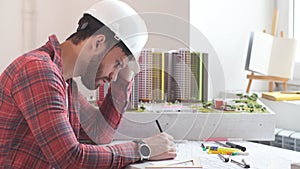 Professional civil engineer working with documents, drawings in office.