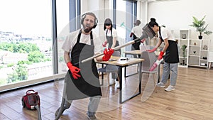 Professional cleaner Caucasian man having fun holding vacuum cleaner like guitar