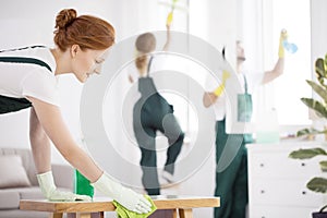 Professional cleaner wiping table photo