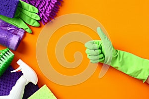 Professional cleaning equipment and supplies with hand in green glove shows thumb up. Cleaning service and housekeeping concept