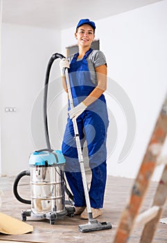 Professional cleaning after renovation in the room - woman vacuums the floor