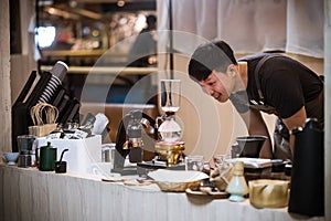 Professional coffee maker - Barista using coffee siphon brewing hot espresso at coffee shop