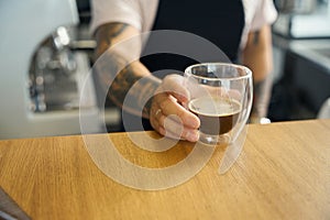 Professional coffee shop worker presenting fresh espresso