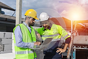 Professional construction engineer team, Two man engineer wear uniform holding laptop standing at construction site. Workers