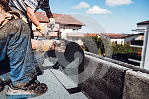 Professional construction worker  installing and waterproofing flat roof at house construction site. Bituminous membrane