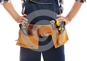 Professional construction worker with tool belt on white background