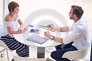 Professional consultant giving business advise to aspirational businesswoman photo