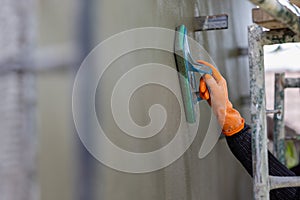 Professional contractor plastering wall with sponge float to make a smooth rendering