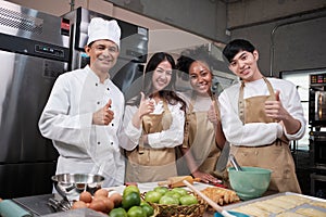 Professional cooking class people team, cheerful smile and thumb up in kitchen