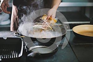 Professional cooking spaghetti in restaurant