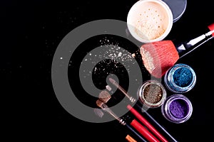 Professional cosmetics and brushes for make-up on a black background