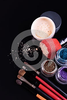 Professional cosmetics and brushes for make-up on a black background