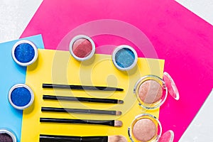 Professional cosmetics, makeup brushes. eyeshadow in bright yellow, pink background, top view, closeup