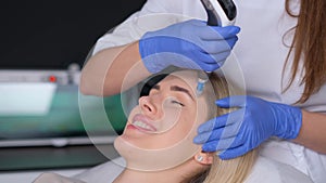 Professional cosmetologist performs DermaPen procedure in a cosmetology clinic.