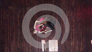 Professional couple dancing tango on the wooden floor in the studio.