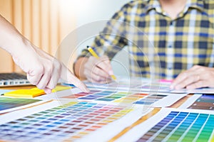 Professional Creative architect graphic desiner occupation choosing the Color pantone palette samples for project on office desk