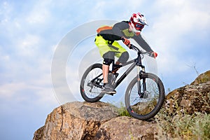 Professional Cyclist Riding the Bike on the Top of the Rock. Extreme Sport Concept. Space for Text.