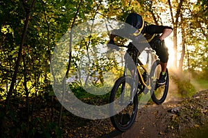 Professional Cyclist Riding the Mountain Bike on the Autumn Forest Trail. Extreme Sport and Enduro Cycling Concept.