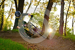 Professional Cyclist Riding the Mountain Bike on the Autumn Forest Trail. Extreme Sport and Enduro Cycling Concept.