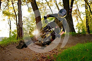 Professional Cyclist Riding the Mountain Bike on the Autumn Forest Trail. Extreme Sport and Enduro Cycling Concept.