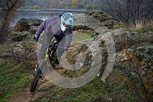 Professional Cyclist Riding Mountain Bike Down the Rocky Hill. Extreme Sport and Enduro Biking Concept.