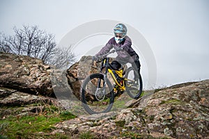 Professional Cyclist Riding Mountain Bike Down the Rocky Hill. Extreme Sport and Enduro Biking Concept.