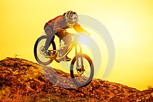 Professional Cyclist Riding Mountain Bike Down the Rocky Hill. Extreme Sport and Enduro Biking Concept.