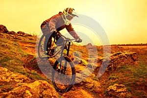 Professional Cyclist Riding Mountain Bike Down the Rocky Hill. Extreme Sport and Enduro Biking Concept.