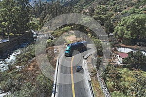 Professional cyclist training on the road with safety escort car. Cyclist followed by team car. Aerial view