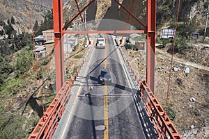 Professional cyclist training on the road with safety escort car. Cyclist followed by team car. Aerial view