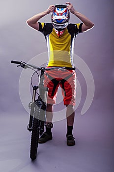 Professional cyclist wearing a helmet on a gray background.