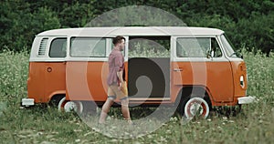 Professional dancer , in the middle of field dacing in front of a retro van.