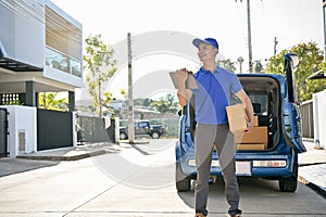 Professional delivery man standing in front of his van, carry his order and package for customer