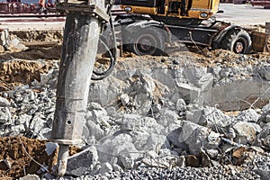 Professional demolition of reinforced concrete structures using industrial hydraulic hammer with excavator. Rods of metal fittings
