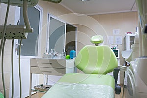 Professional dental unit with green chair and tools. Dentistry, medicine, medical equipment and stomatology concept