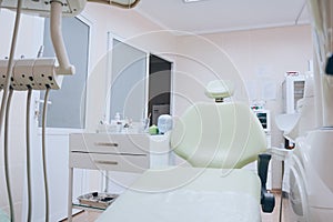 Professional dental unit with green chair and tools. Dentistry, medicine, medical equipment and stomatology concept. White tone