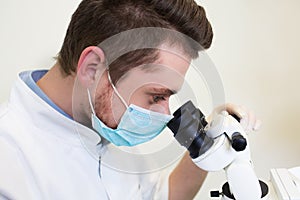 Professional dentist examination patient with microscope at the office.Dentist looking through microscope at surgery office.Close