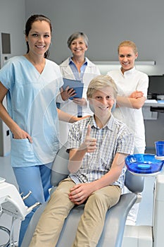 Professional dentist team with boy patient thumbup