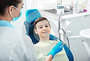 Professional dentist working with little patient in clinic