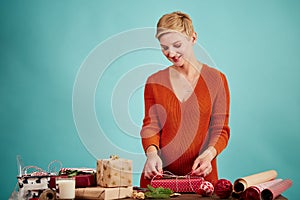 Professional designer holds gift and wrapping paper in hand.