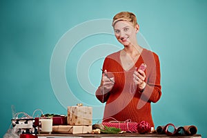 Professional designer holds gift and wrapping paper in hand.