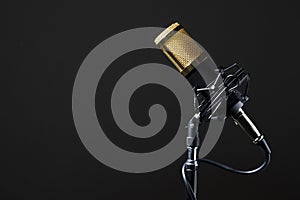 Professional desktop microphone with cable and mounted on its base with a black background.