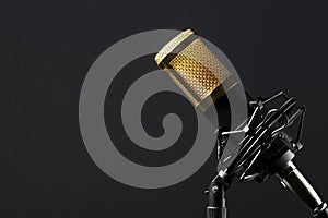 Professional desktop microphone with cable and mounted on its base with a black background.