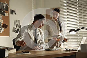 Professional detectives working at desk in office