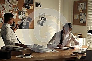 Professional detectives working at desk in office