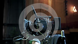 Professional digital cinema camera with set of light hanging in studio background.