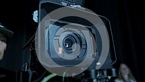 Professional digital cinema camera with set of light hanging in studio background. Close up