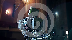 Professional digital cinema camera with set of light hanging in studio background. move camera